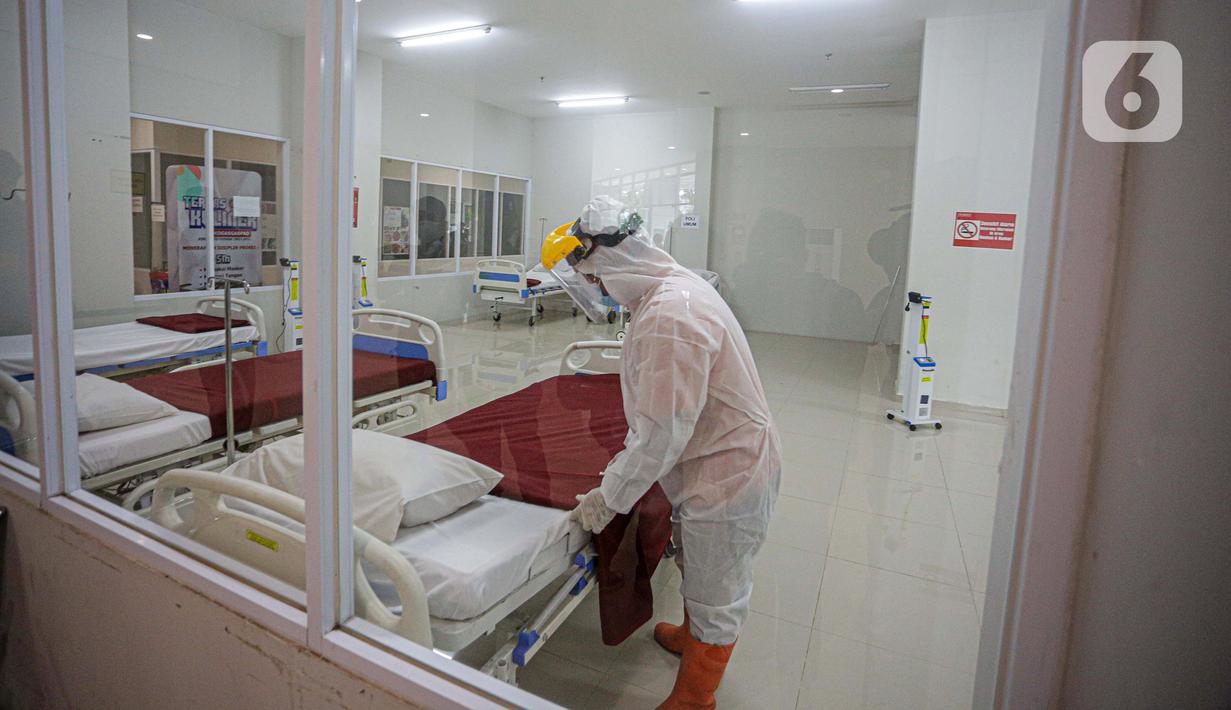 Petugas mengenakan hazmat saat menyiapkan tempat tidur di Tower 8 Wisma Atlet Pademangan, Jakarta, Selasa (15/6/2021). Tower 8 Wisma Atlet Pademangan bisa menampung 1.569 pasien untuk isolasi. (Liputan6.com/Faizal Fanani)