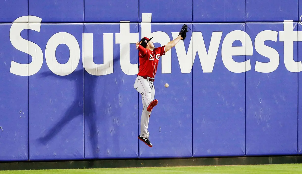 Pemain Cincinnati Reds, Adam Duvall gagal menangkap bola pukulan pemain Texas Rangers, Shin-Soo Choo selama inning ketiga dari pertandingan bisbol pramusim di Arlington, Texas (26/3). Texas menang 6-5. (AP Photo/Brandon Wade)
