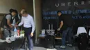 Polisi Hong Kong melakukan razia di kantor jasa pelayanan taxi Uber Inc, Selasa (11/8/2015). Polisi berhasil mengamankan 5 orang yang tertangkap basah memberikan jasa pelayanan sebagai sopir taxi dengan kendaraan ilegal. (REUTERS/Apple Daily)