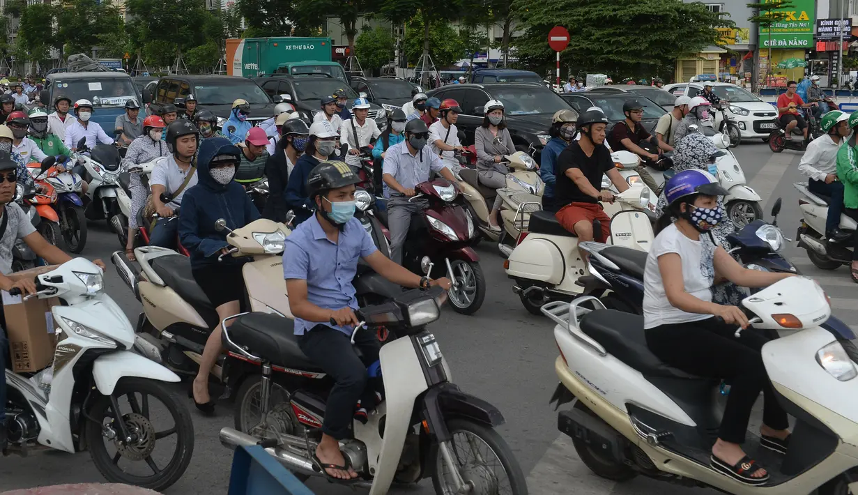 Pengendara motor melintas pada jam sibuk di sebuah jalan pusat kota Hanoi, Vietnam, 4 Juli 2017. Pemerintah melarang sepeda motor masuk kota untuk mengurangi kemacetan dan melipatgandakan armada angkutan publik berbasis bus. (AFP PHOTO/HOANG DINH Nam)