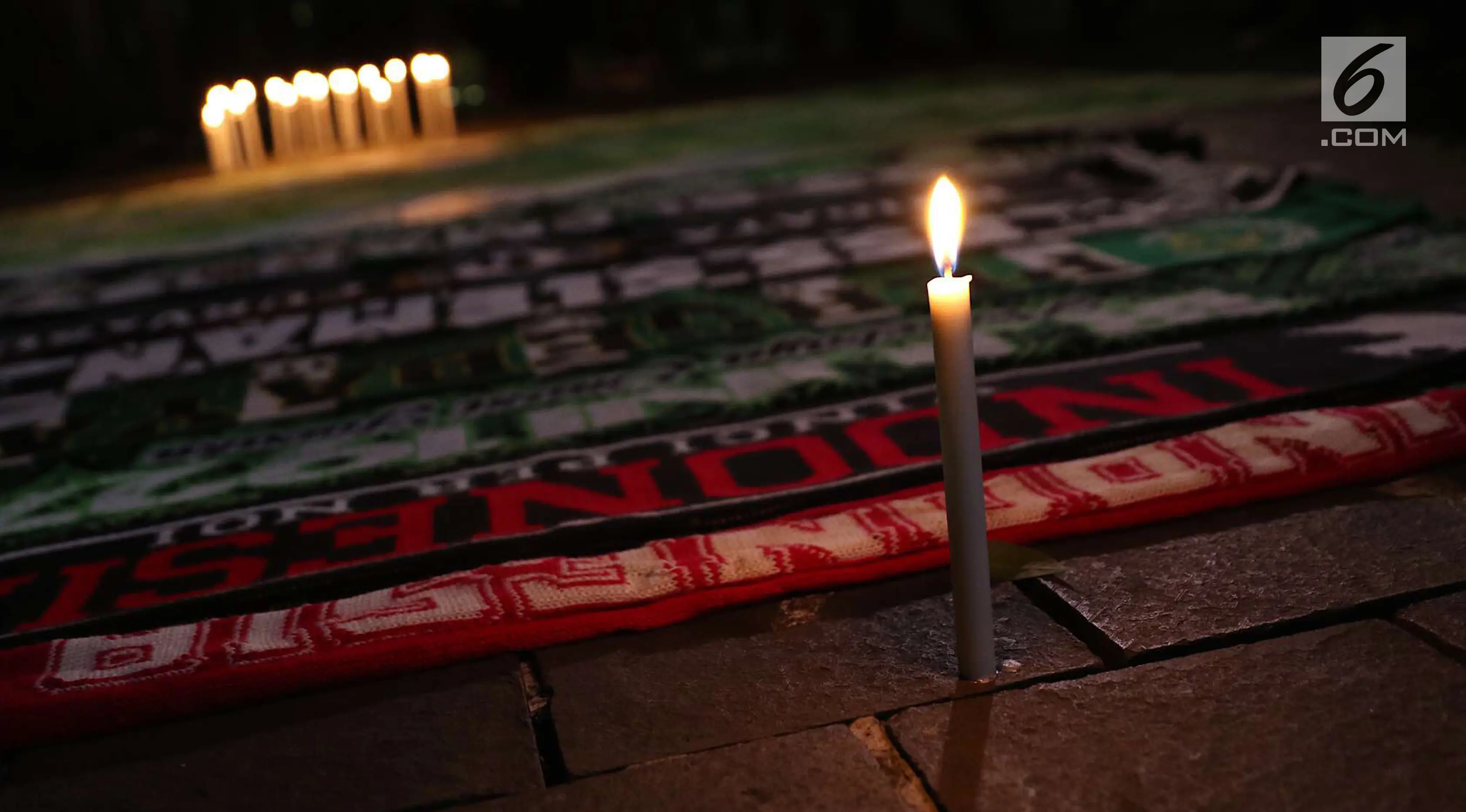 Syal gabungan suporter klub sepak bola dalam aksi lilin terkait solidaritas tragedi teror bom di Surabaya dan Sidoarjo di Taman Suropati, Jakarta, Senin (14/5). (Liputan6.com/Immanuel Antonius)