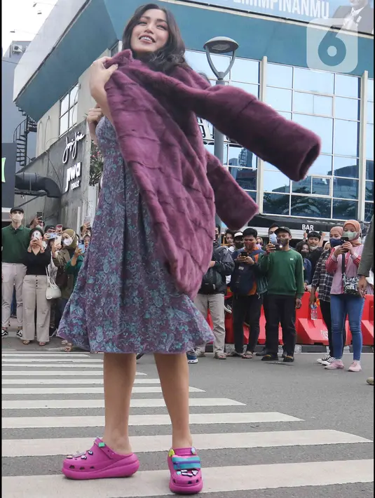 Artis Jessica Iskandar berlenggak-lenggok di zebra cross Dukuh Atas saat meramaikan Citayam Fashion Week di kawasan SCBD (Sudirman Citayam Bojong Gede Dukuh Atas), Dukuh Atas, Jakarta Pusat, Senin (25/7/2022). Jessica Iskandar tampak anggun mengenakan gaun bunga-bunga dengan luaran blazer bewarna ungu. (Liputan6.com/Herman Zakharia)
