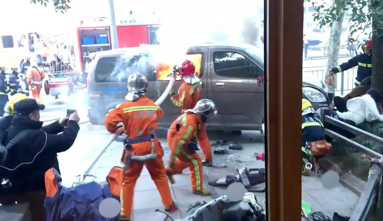 Petugas pemadam kebakaran memadamkan api dari sebuah van yang tiba-tiba menabrak para pejalan kaki di trotoar daerah sibuk di Shanghai, China, Jumat (2/2). Sebanyak 18 orang luka-luka dan tiga di antaranya berada dalam kondisi kritis. (AP Photo)