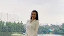 Main golf, Aura Kasih tampil stylish mengenakan jaket olahraga berwarna putih dipadukan mini skirt warna lilac dan sneakers warna abu-abu. (Instagram/aurakasih)..