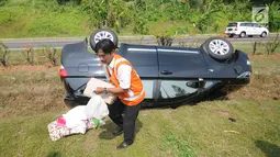 Petugas menunjukkan SIM A milik sopir mobil Innova yang terbalik di KM 208 Tol Palikanci (Palimanan-Kanci), Jawa Barat, Rabu (21/6). Sopir mobil itu diduga mengantuk dan membanting setir hingga mengakibatkan mobil terbalik. (Liputan6.com/Gempur M Surya)