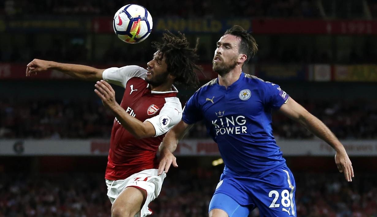 Gelandang Arsenal, Mohamed Elneny, duel udara dengan bek Leicester, Christian Fuchs,  pada laga Premier League di Stadion Emirates, London, Jumat (11/8/2017). Arsenal menang 4-3 atas Leicester. (AFP/Ian Kington)