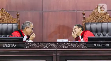 Ketua Mahkamah Konstitusi (MK) Suhartoyo (kanan) berbicara dengan Hakim Konstitusi Saldi Isra (kiri) di sela sidang perkara Nomor 145/PUU-XXI/2023 di Gedung MK, Jakarta, Selasa (16/1/2024). (Liputan6.com/Angga Yuniar)