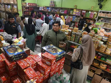 Pembeli melakukan pembayaran kue kering pada toko kue yang berada di sekitar Pabrik Kue Khong Guan di Ciracas, Jakarta Timur, Rabu (26/3/2025). (merdeka.com/Arie Basuki)