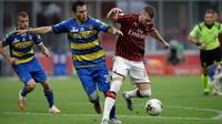 Penyerang AC Milan, Ante Rebic membawa bola dari kawalan pemain Parma, Matteo Darmian pada pertandingan lanjutan Liga Serie A Italia di Stadion San Siro di Milan, Italia (15/7/2020). AC Milan menang telak 3-1 atas Parma. (AP Photo/Luca Bruno)