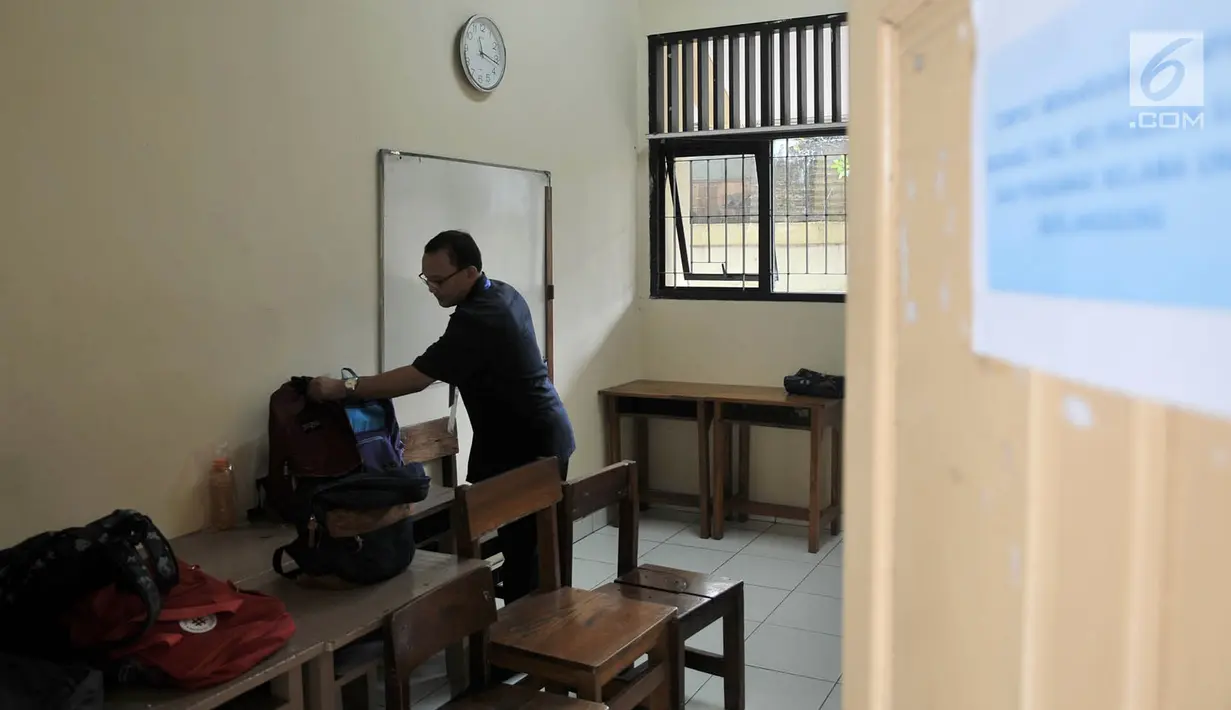 Seorang guru pengawas merapikan tas para siswa peserta UNKP di ruang khusus SLB Negeri 7 Jakarta, Selasa (24/4). Seluruh siswa yang mengikuti ujian tersebut merupakan penyandang tunarungu. (Merdeka.com/Iqbal Nugroho)