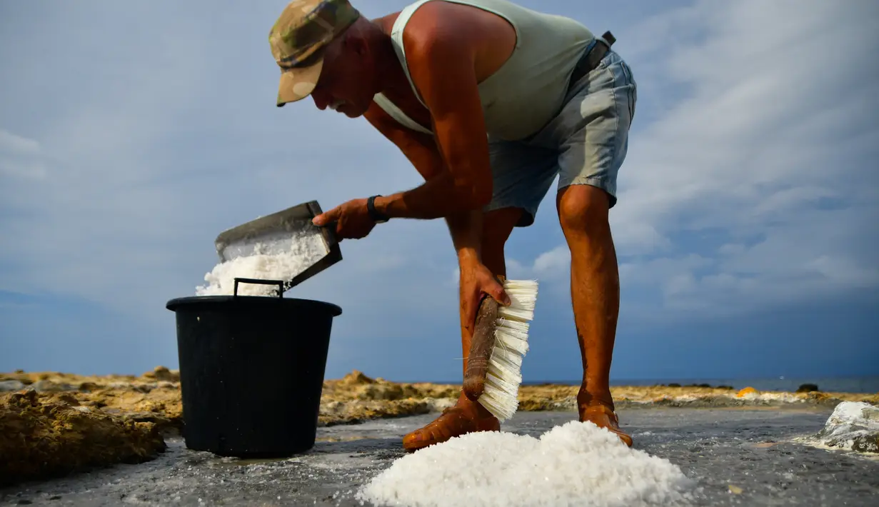 Alfred Attard mengumpulkan garam laut dari dataran garam dengan pematang batu di sebuah desa di Gozo, Malta, pada 7 September 2020. Dikelilingi seluruhnya oleh laut, Malta merupakan salah satu produsen besar garam laut yang dihasilkan dari dataran garam berpematang batu. (Xinhua/Jonathan Borg)