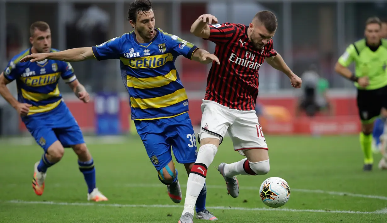 Penyerang AC Milan, Ante Rebic membawa bola dari kawalan pemain Parma, Matteo Darmian pada pertandingan lanjutan Liga Serie A Italia di Stadion San Siro di Milan, Italia (15/7/2020). AC Milan menang telak 3-1 atas Parma. (AP Photo/Luca Bruno)