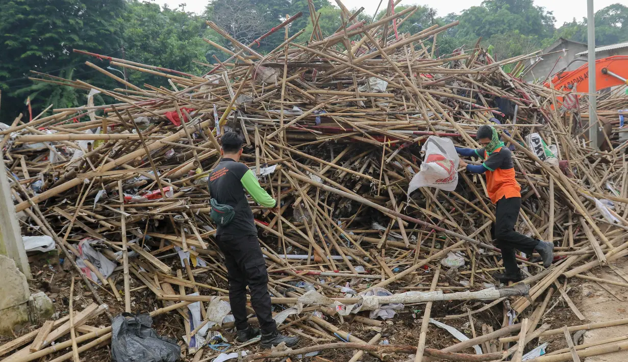 Petugas sedang memilah tumpukan bambu bekas sisa alat peraga kampanye di tempat penyaringan sampah di TB Simatupang, Jakarta, Jumat (16/2/2024). (Liputan6.com/Herman Zakharia)