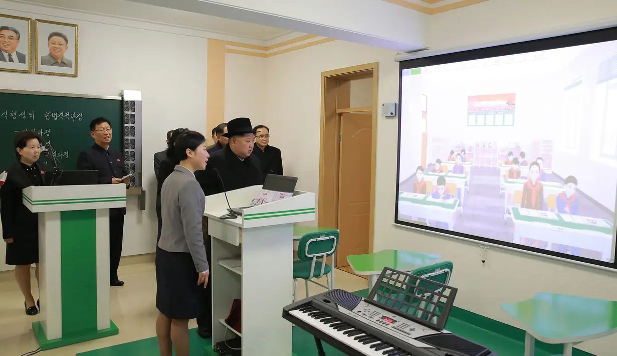 Pemimpin Korea Utara Kim Jong-Un melihat layar saat mengunjungi Universitas Guru Pyongyang yang baru direnovasi di Pyongyang (17/1). (KCNA VIA KNS/AFP)