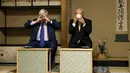 Walikota London Boris Johnson (kiri) meneguk teh  dalam perjamuan teh di Kuil Meiji, Tokyo, Rabu (14/10/2015). Johnson mengajak pemerintah Tokyo berkerja sama untuk  mendorong Investasi, lapangan pekerjaan dan pertumbuhan ekonomi. (REUTERS/Issei Kato)