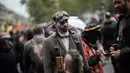 Penggemar film horor memakai kostum dan berdandan menyerupai zombie saat berpartisipasi dalam acara Zombie Walk di Place de la Republique, Paris, Sabtu (12/10/2019). Sejak 2008, acara Zombie Walk digelar untuk orang-orang yang terobsesi dengan mayat hidup. (Martin BUREAU / AFP)