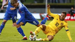 Penyerang Belgia, Eden Hazard, berebut bola dengan pemain Islandia, Birkir Bjarnason, pada laga UEFA Nations League di Stadion Laugardalsvollur, Selasa (11/9/2018). Belgia menang 3-0 atas Islandia. (AP/Brynjar Gunnarsson)