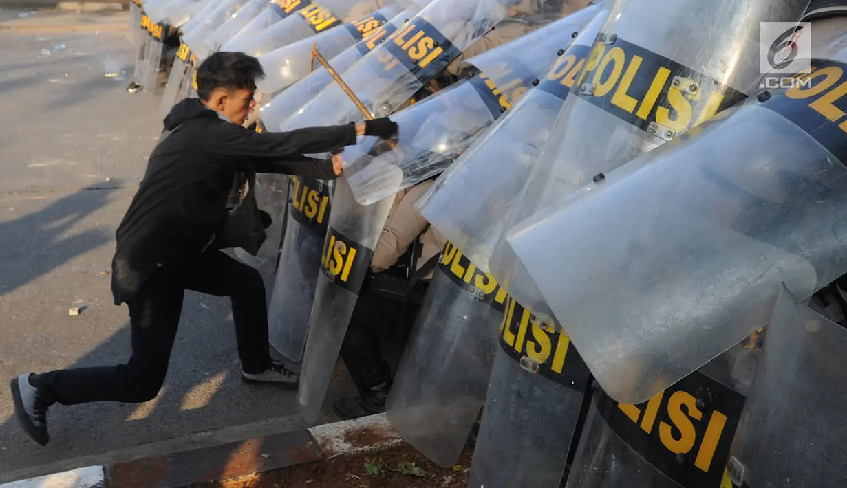 Massa aksi memukul polisi yang membentuk barikade dengan tameng di dekat Gedung DPR/MPR, Jalan Gatot Subroto, Jakarta, Senin (30/9/2019). Aksi unjuk rasa dari berbagai elemen tersebut menyikapi penolakan terhadap UU KPK dan sejumlah RUU yang dinilai bermasalah. (merdeka.com/Arie Basuki)