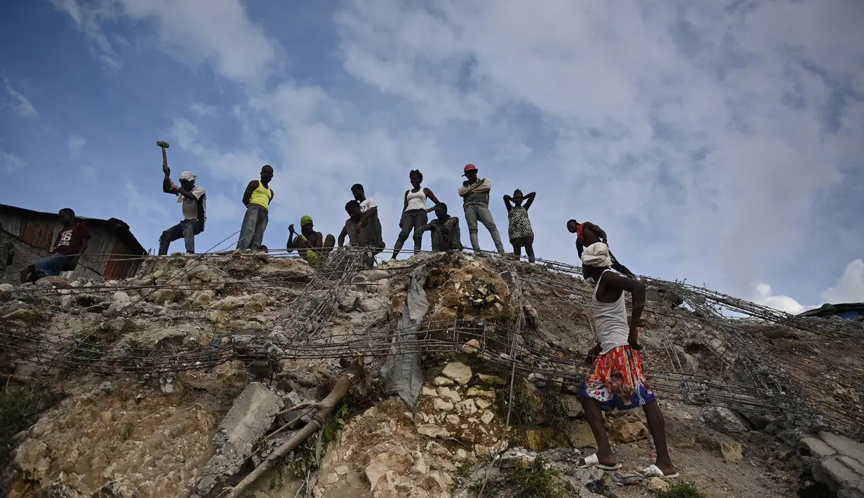 Orang-orang bekerja di antara puing-puing setelah gempa bumi melanda Haiti barat di Jeremie, Haiti pada 6 Juni 2023. (AFP/Richard Pierrin)