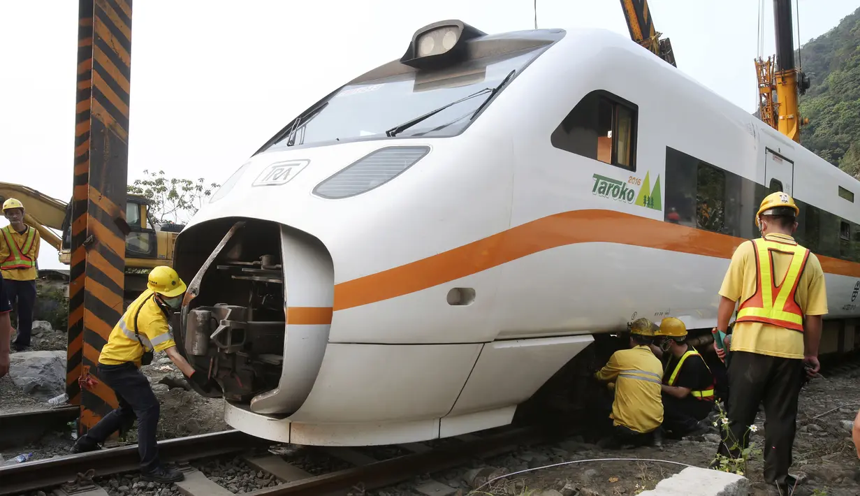 Petugas penyelamat memindahkan bagian dari kereta yang tergelincir dekat Ngarai Taroko di Hualien, Taiwan, Sabtu (3/4/2021). Penumpang kereta kebanyakan turis untuk merayakan long weekend. (AP Photo/Chiang Ying-ying)