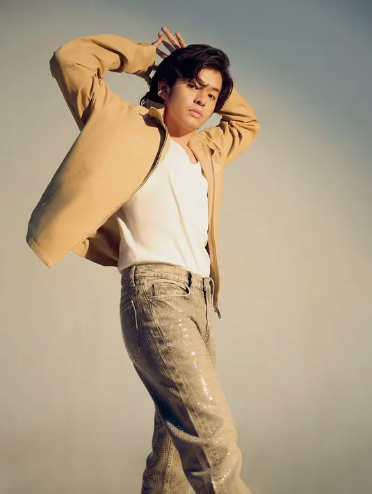 Angga Yunanda tampil mengenakan kaus putih yang ditumpuk dengan jaket kulit cokelat dan sequin pants abu-abu, serta sepatu hitam. [Foto: Instagram/angga]