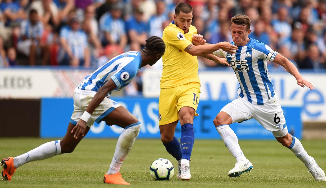 Gelandang Chelsea, Eden Hazard, berusaha melewati pemain Huddersfield Town pada laga Premier League di Stadion John Smith's, Sabtu (11/8/2018). Chelsea menang 3-0 atas Huddersfield Town. (AFP/Oli Scarff)
