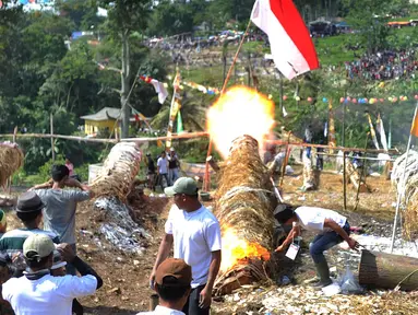 Warga menyalakan meriam karbit selama kegiatan Pesta Rakyat Sukamakmur di Desa Sukamakmur, Bogor, Minggu (16/6/2019). Kegiatan berupa perang meriam karbit yang terbuat dari batang pohon kapuk antar desa setelah perayaan lebaran ini terakhir diselenggarakan 13 tahun silam. (merdeka.com/Arie Basuki)