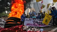 Mahasiswa membakar ban bekas saat aksi unjuk rasa atau demo BBM naik di kawasan Patung Kuda, Jakarta, Senin (5/9/2022). Mereka datang membawa atribut bendera organisasi hingga spanduk tuntutan menolak kenaikan BBM. (Liputan6.com/Angga Yuniar)