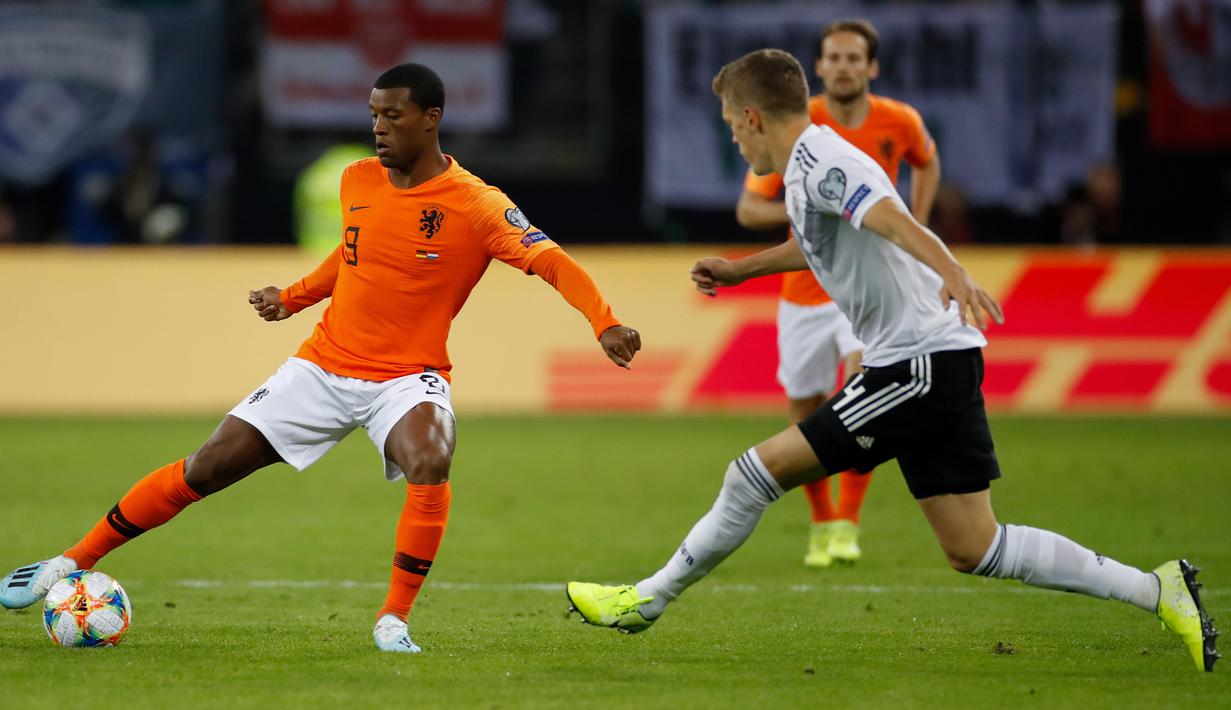 Gelandang Belanda, Georginio Wijnaldum, berusaha melewati bek Jerman, Matthias Ginter, pada laga Kualifikasi Piala Dunia 2022 di Hamburg, Jumat (6/9). Jerman kalah 2-4 dari Belanda. (AFP/Patrik Stollarz)