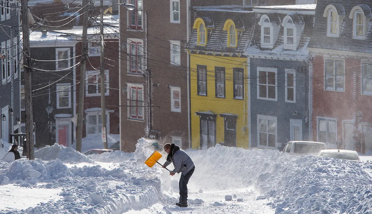 Warga menggali salju untuk membuat jalan dari rumahnya di Kota St John's, Newfoundland, Kanada, Sabtu (18/1/2020). St John's menghadapi keadaan darurat ketika salju tebal memaksa pusat-pusat bisnis tutup dan kendaraan dilarang melintas di jalan raya. (Andrew Vaughan/The Canadian Press via AP)