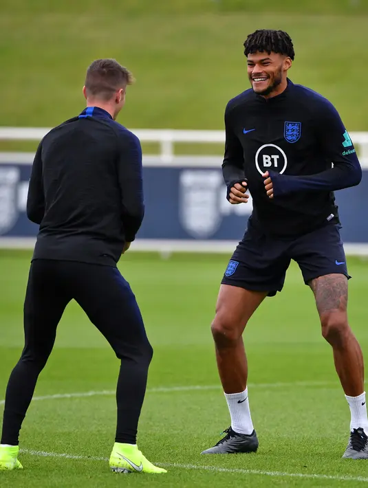 Bek Inggris Tyrone Mings (kanan) dan gelandang tengah Inggris Mason Mount (kiri) melakukan pemanasan saat mengikuti sesi latihan tim di St George's Park di Burton-on-Trent (6/9/2019). (AFP Photo/Paul Ellis)