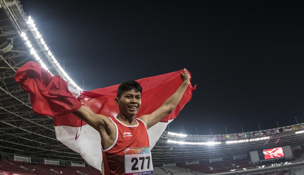 Pelari Indonesia, Sapto Yogo Purnomo, melakukan selebrasi usai meraih medali emas cabang atletik nomor lari 200 meter T 37 Asian Para Games di SUGBK, Jakarta, Senin (8/10/2018). (Bola.com/Vitalis Yogi Trisna)