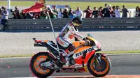 Pembalap Spanyol Repsol Honda, Marc Marquez membawa bendera di atas motor setelah memenangkan balapan seri ke 18 MotoGP Grand Prix Valencia di Sirkuit Ricardo Tormo, Valencia (12/11). Marc Marquez finis di urutan ketiga. (AFP PHOTO / Jose Jordan)
