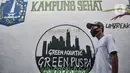 Warga melintasi mural logo Kampung Sehat di Utan Kayu Selatan, Jakarta, Rabu (11/11/2020). (merdeka.com/Iqbal S. Nugroho)