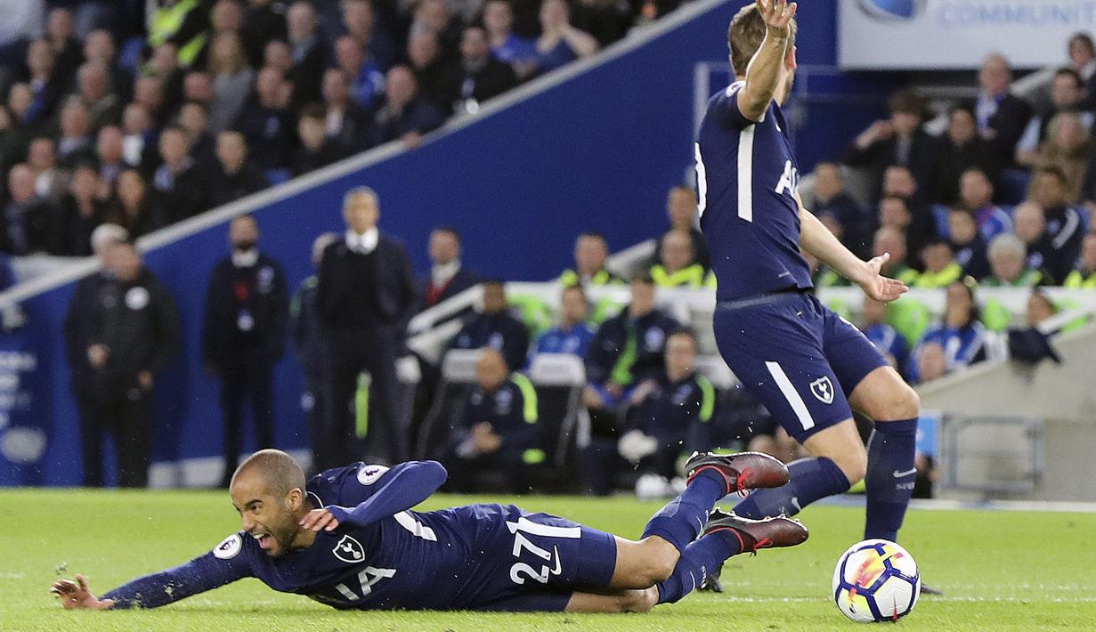 Pemain Tottenham Hotspur, Lucas Moura jatuh saat berebut bola dengan pemain Brighton pada lanjutan Premier League di AMEX Stadium, Brighton, (17/4/2018). Tottenham bermain imbang 1-1 lawan Brighton. (Gareth Fuller/PA via AP)