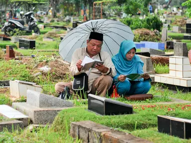 Warga membacakan doa di makam keluarganya menjelang bulan puasa di TPU Karet Bivak, Jakarta, Minggu (29/5/2016). Jelang bulan Ramadan, umat Muslim mulai ramai berziarah ke makam keluarganya. (Liputan6.com/Yoppy Renato)