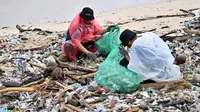 Sejumlah sukarelawan dan wisatawan turun tangan untuk membersihkan Pantai Kedonganan, Bali dari ceceran sampah. (SONNY TUMBELAKA/AFP)