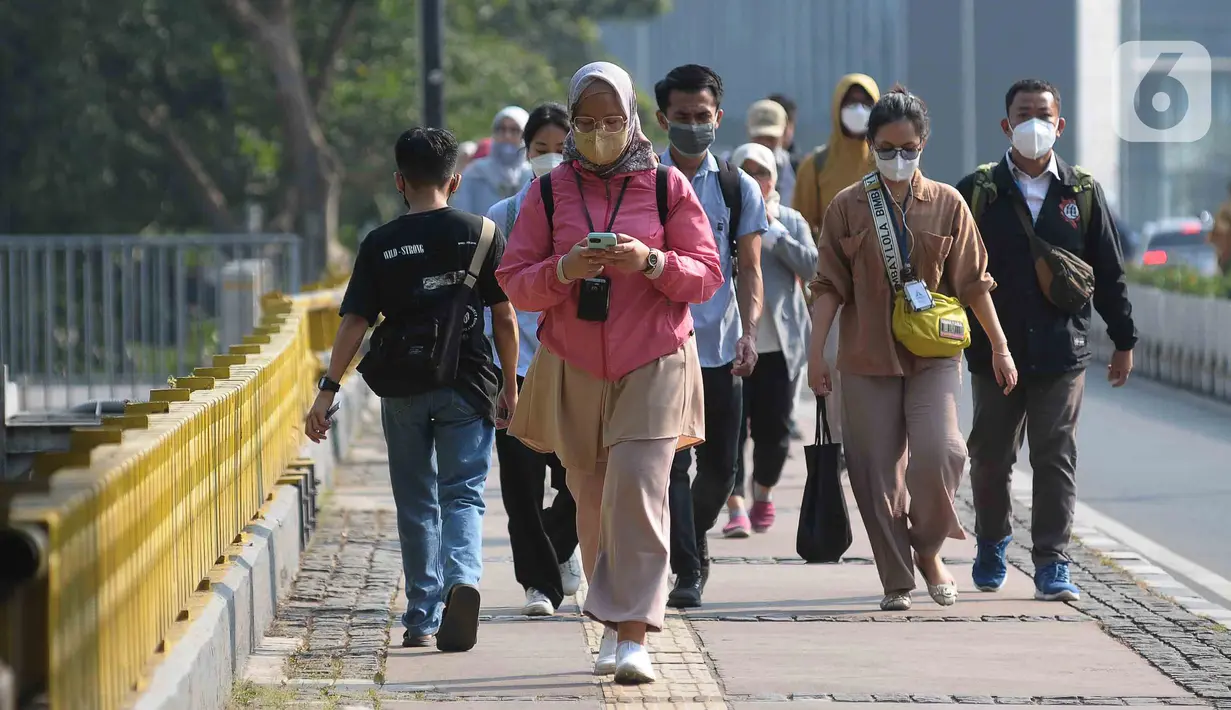 Pekerja berjalan menuju kantor mereka masing-masing di sepanjang Jalan Kawasan Sudirman-Thamrin, Jakarta, Senin (14/8/2023). (merdeka.com/Imam Buhori)