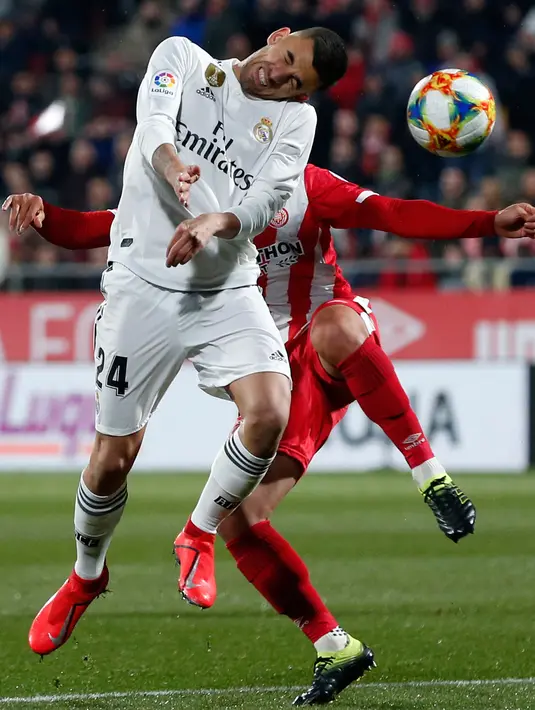 Duel gelandang Real Madrid, Daniel Ceballos dan pemain Girona, Paik Seung-ho pada leg kedua perempat final Copa del Rey di Stadion Municipal de Montilivi, Kamis (31/1). Real Madrid melangkah ke semifinal Copa del Rey  dengan skor 3-1. (PAU BARRENA/AFP)