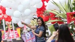 Seorang warga berpose sambil memegang balon yang berada di halaman Balai Kota, Jakarta, Senin (8/5). Balon itu merupakan bentuk dukungan moril untuk Ahok yang besok akan menjalani sidang putusan kasus dugaan penodaan agama. (Liputan6.com/Faizal Fanani)