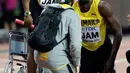 Pelari Jamaika, Usain Bolt mendapat perawatan usai terjatuh karena cedera di final 4x100 meter pada Kejuaraan Dunia Atletik, Sabtu (12/8). Pemegang rekor pelari tercepat di dunia itu terkapar di lintasan dan gagal melanjutkan lomba. (AP/David J. Phillip)