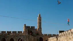 Slackliner Amerika, Heather Larsen saat beraksi melintasi dua menara Museum David di Yerusalem 2 Mei 2016. Slackline merupakan olahraga untuk melatih keseimbangan diatas seutas tali yang dibentangkan dengan berbagai macam ketinggian. (REUTERS / Nir Elias)