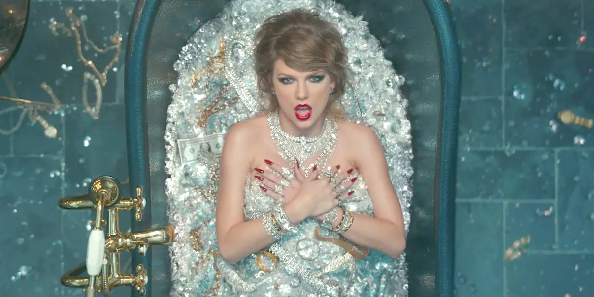 	Taylor Swift dalam videoklip Look What You Made Me Do memamerkan kekayaan dalam tumpukan batu permata (YouTube)