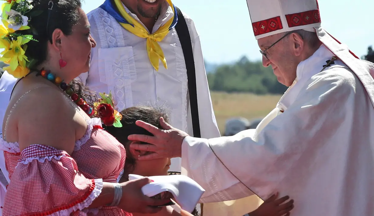 Seorang anak mengulurkan tangan untuk memeluk Paus Fransiskus dalam acara Misa di Pangkalan Udara Maquehue, di Temuco, Chili (17/1). (AP Photo/Alessandra Tarantino)