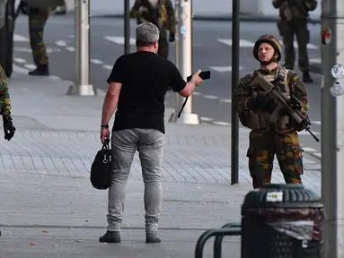 Tentara Belgia berbincang dengan seorang pria di luar Central Station usai sebuah teror ledakan yang terjadi di Brussels, Belgia (20/6). Media Belgia melaporkan bahwa ledakan terjadi di stasiun kereta api Gare Centrale. (AP Photo/Geert Vanden Wijngaert)
