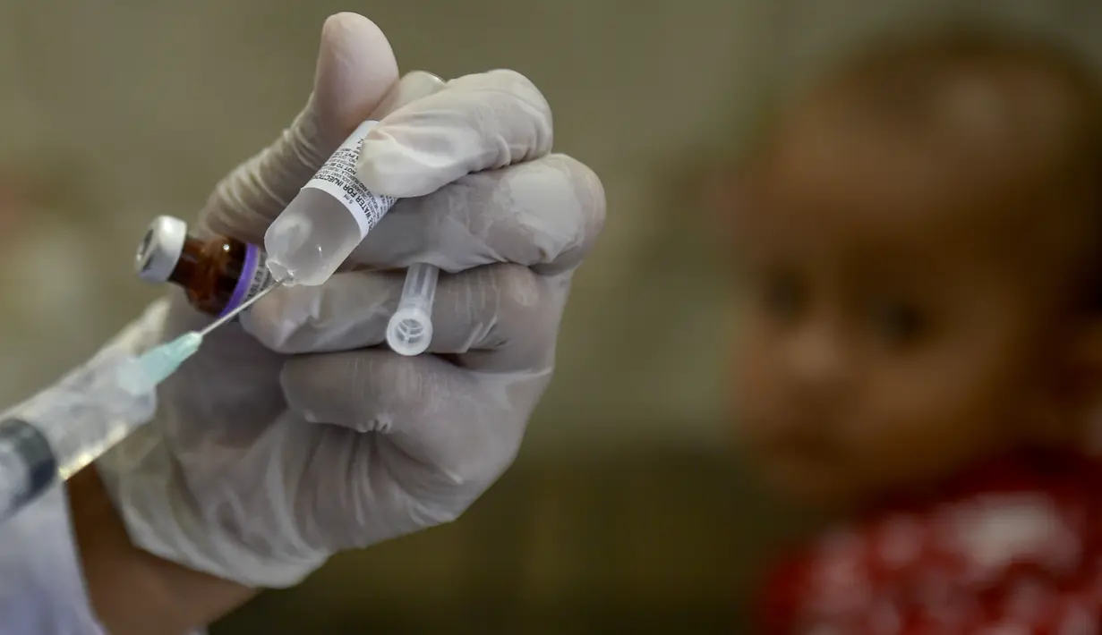 Seorang petugas kesehatan bersiap untuk memberikan vaksin polio kepada balita di sebuah posyandu di Banda Aceh, Aceh, Rabu (4/10/2020). Pemberian vaksin polio dan vaksin campak secara gratis yang berlanjut di tengah pandemi COVID-19 bertujuan memperkuat imunitas anak. (CHAIDEER MAHYUDDIN / AFP)
