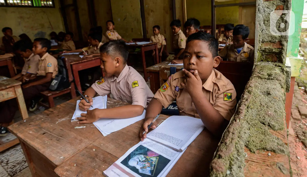 Murid SDN Samudrajaya 04 mengikuti proses belajar mengajar di Ruang Kelas 5, Desa Samudrajaya, Kecamatan Tarumajaya, Kabupaten Bekasi, Jawa Barat, Selasa (21/1/2020). Murid SDN Samudrajaya 04 terpaksa belajar di gedung sekolah yang rusak sejak tahun 2014. (merdeka.com/Imam Buhori)