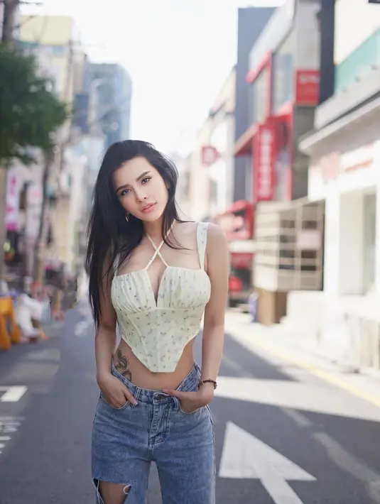 Dalam unggahannya baru-baru ini, Wanita asal Bandung itu tampil modis memadukan corset top putih bermotif floral dengan celana jeans bergaya kasual. Atasan korset dengan belahan dada rendah itu menampilkan kesan seksi yang menggoda.  (Instagram/maria_vaniaa)