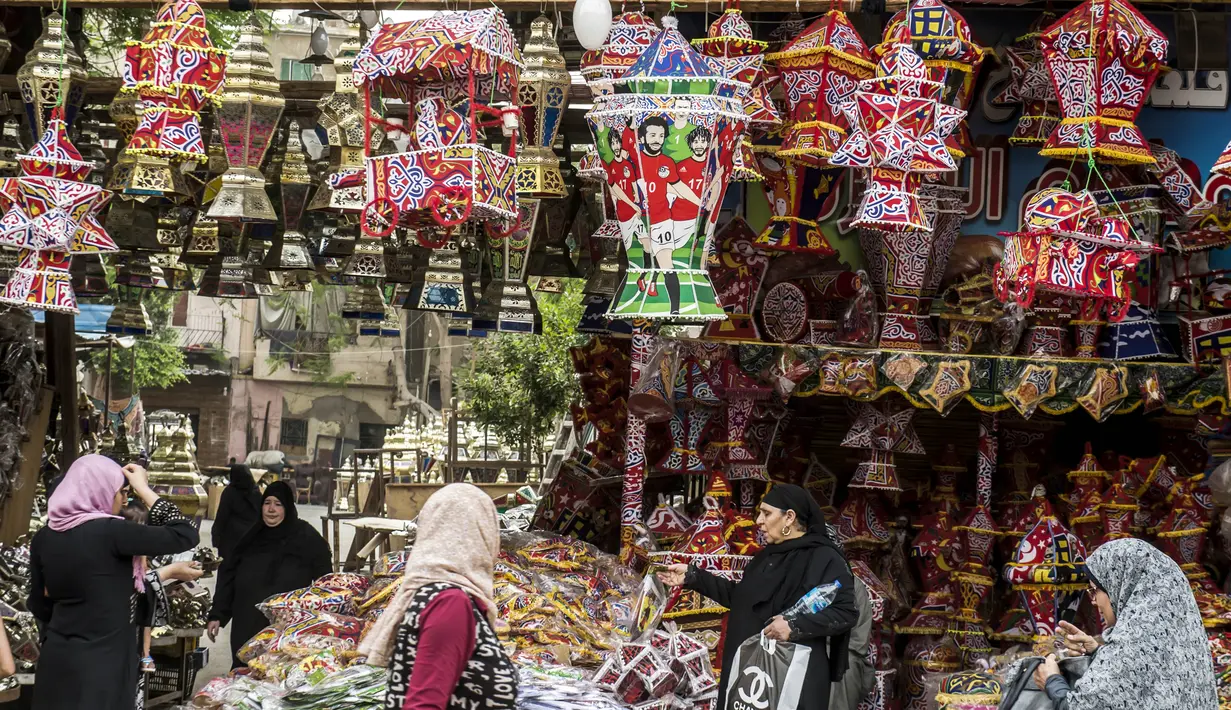 Sejumlah warga mengunjungi toko yang menjual pernak-pernik bertema Mohamed Salah di Kairo, Mesir, Senin (30/5/2018). Menjadi pahlawan baru bagi rakyat Mesir, pernak pernik Mohamad Salah laris manis. (AFP/Khaled Desouki)