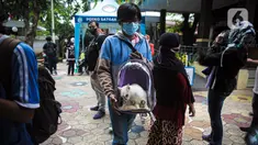 Warga membawa kucing untuk disuntik vaksin antirabies secara gratis di kawasan Tebet, Jakarta, Selasa (16/11/2021). Vaksinasi dilakukan untuk menghindari dan mengantisipasi penyebaran penyakit rabies kepada hewan peliharaan. (Liputan6.com/Faizal Fanani)